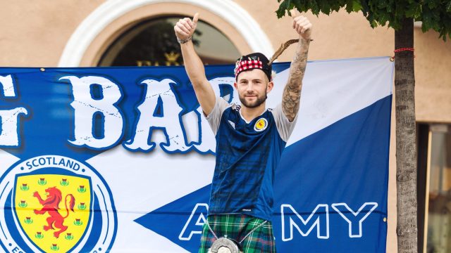 Young Scotland football team fan in national costume cheering and posing on the street in Vilnius, Lithuania — Photo by Cebas1
